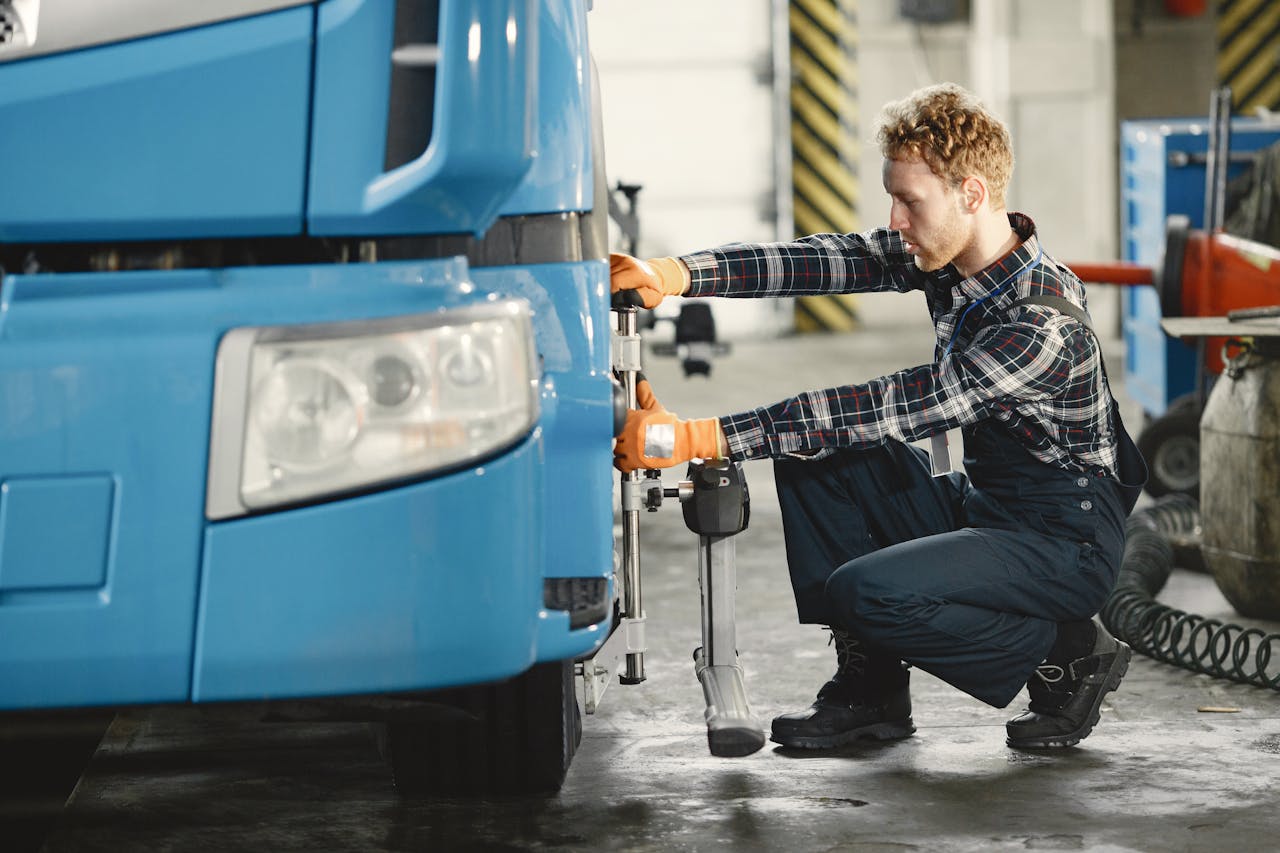 A male mechanic is aligning truck tires in a professional workshop setting.